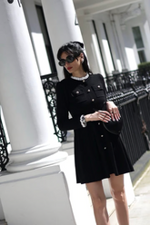 a lady in a black ruffle collared black dress